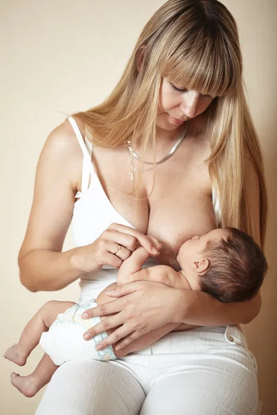 Joven madre alimentando a su pequeño bebé — Foto de Stock