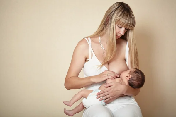 Junge Mutter füttert ihr kleines Baby — Stockfoto