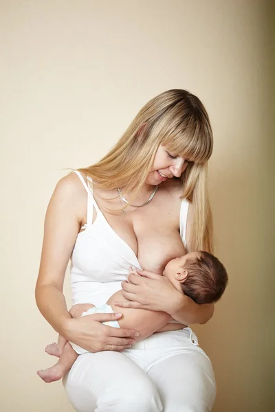Joven madre alimentando a su pequeño bebé — Foto de Stock
