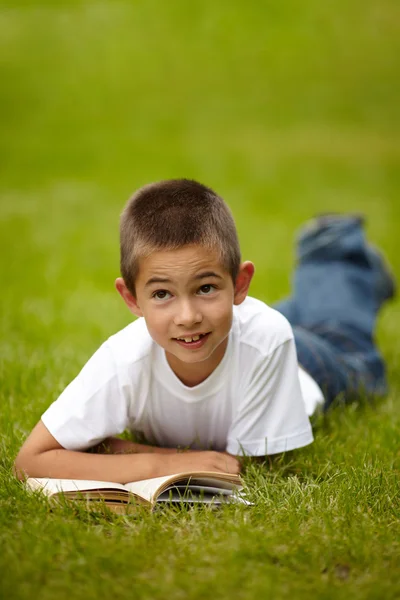 Маленький счастливый мальчик читает книгу — стоковое фото