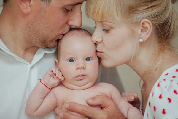 Happy mother and father kissing baby — Stock Photo, Image