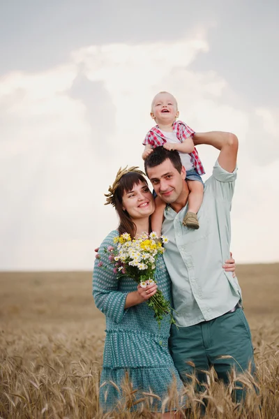 Família feliz no campo de trigo — Fotografia de Stock