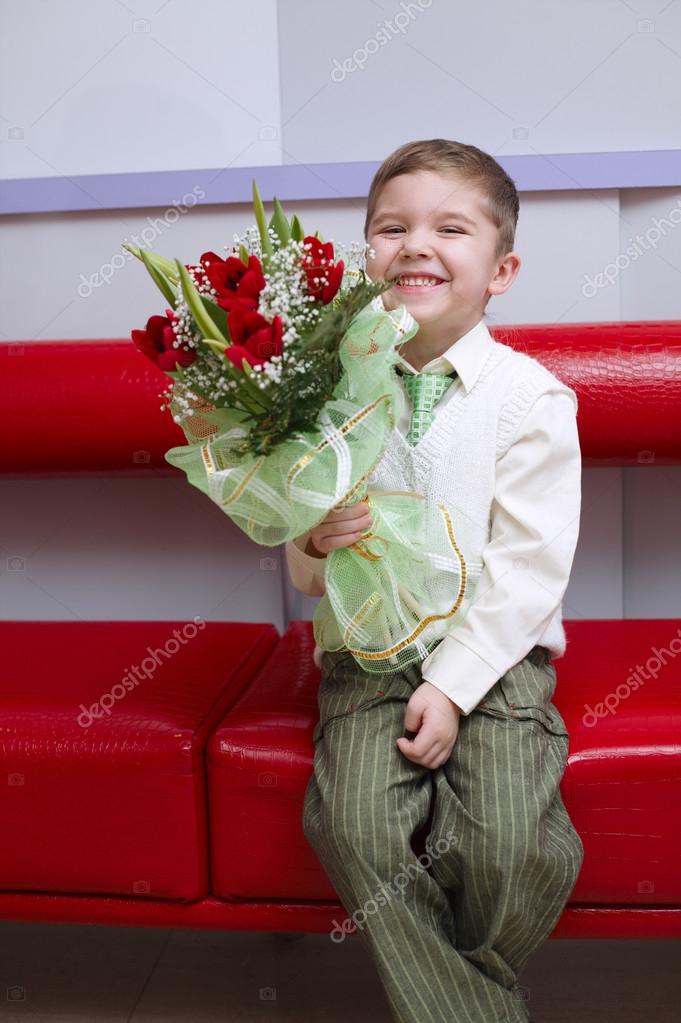 Boy with flowers bouquet sitting on couch Stock Photo by ©ababaka 121676984