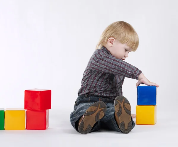 Little boy plays with colorful cubes — Stock Photo, Image