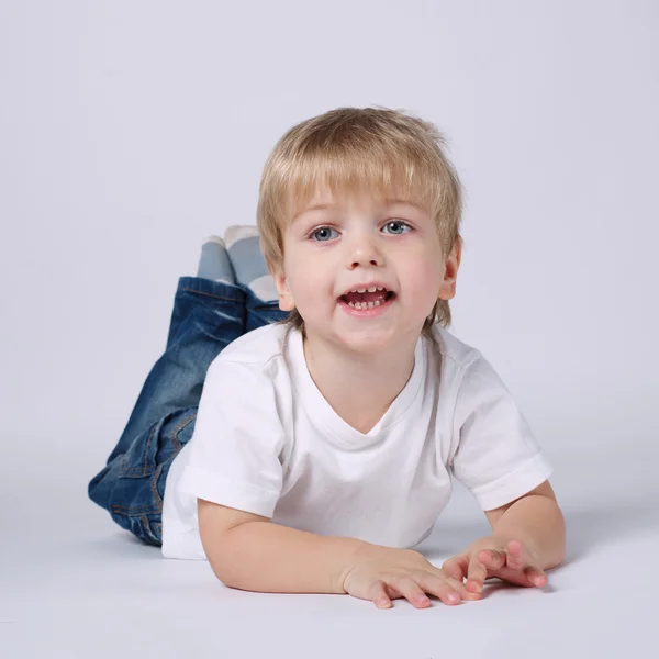 Boy lying on bright background — Stock Photo, Image