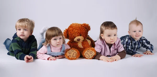 Crianças e urso vermelho no fundo brilhante — Fotografia de Stock