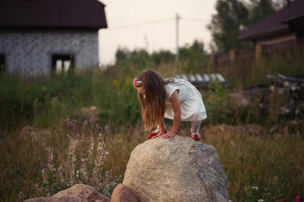 Маленькая девочка на большом камне — стоковое фото