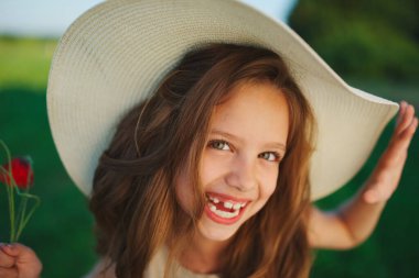 Kırmızılı küçük şirin kız çayırda