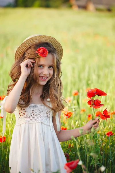 Menina bonito no prado com papoilas vermelhas — Fotografia de Stock