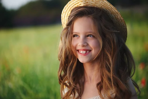 빨간 양귀비를 든 초원의 귀여운 소녀 — 스톡 사진