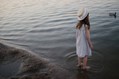 Gölde uzun saçlı, küçük tatlı kız.