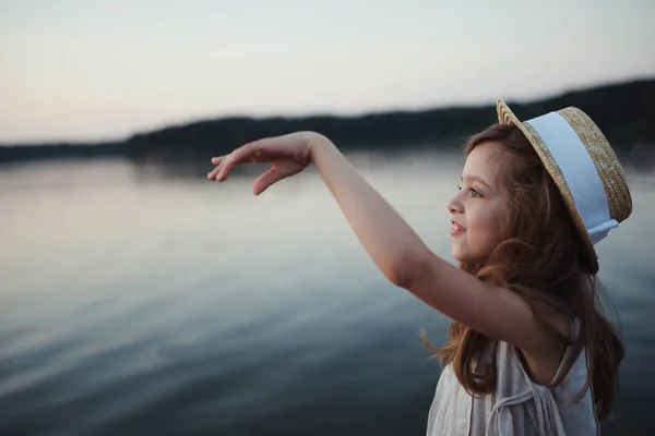 Klein schattig meisje met lang haar op het meer — Stockfoto
