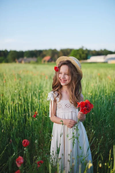 Aranyos kislány a réten vörös mák — Stock Fotó