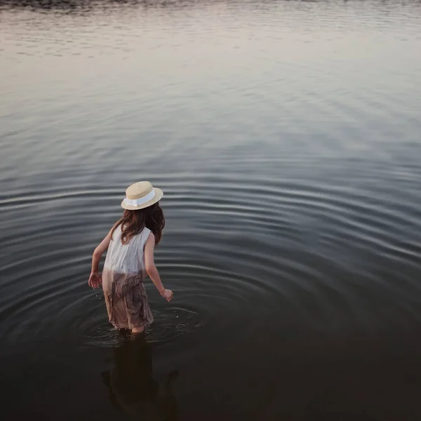 Маленька мила дівчинка з довгим волоссям на озері Стокове Фото
