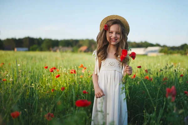 Menina bonito no prado com papoilas vermelhas — Fotografia de Stock