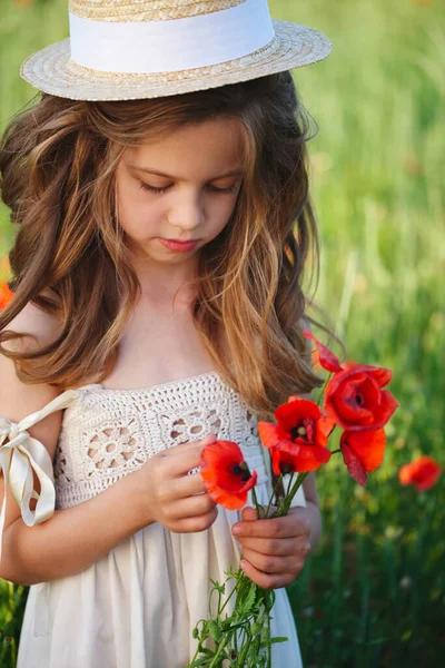 Cute little girl in meadow with red poppies Royalty Free Stock Photos