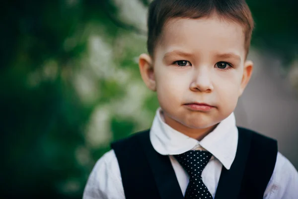 Liten seriös smart pojke bär kostym — Stockfoto