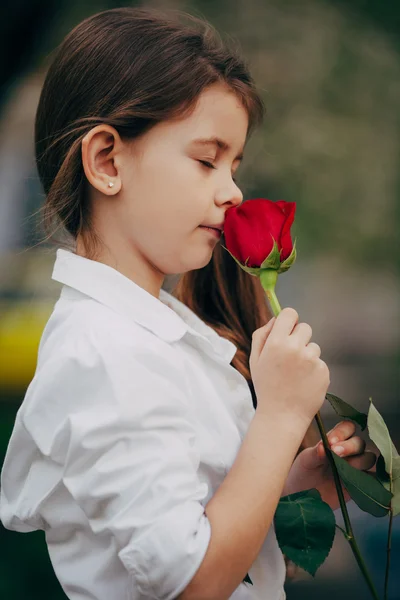 Menina cheiro rosa ao ar livre — Fotografia de Stock