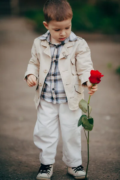 Petit garçon avec rose rouge — Photo