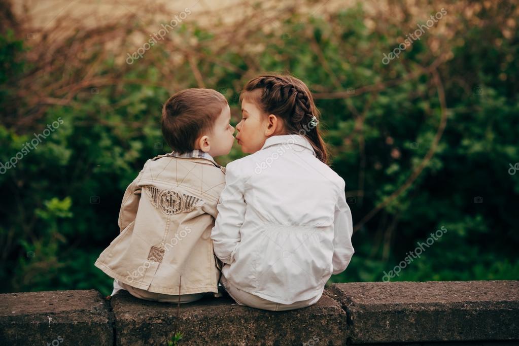 Старшая и младшая сестра. Мальчик целует младшего брата. Детский поцелуй. Сестру двоюродную целую. Любовь между детьми.