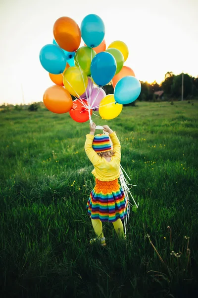 Маленькая девочка с цветными воздушными шарами — стоковое фото