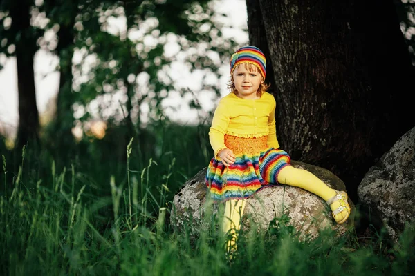 Niña sentada en piedra grande — Foto de Stock