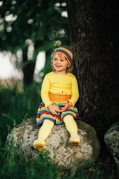 Little girl sitting on big stone — Stock Photo, Image