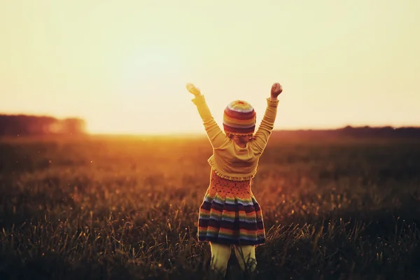 Malá dívka runnig na západ slunce — Stock fotografie