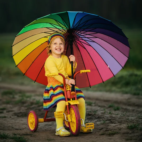 Bambina in bicicletta con ombrello — Foto Stock