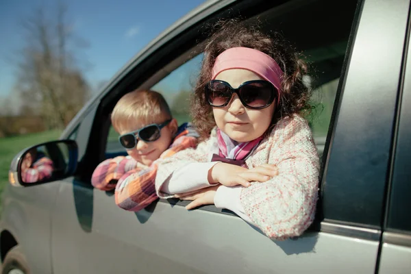 Маленькая девочка и мальчик за рулем автомобиля — стоковое фото