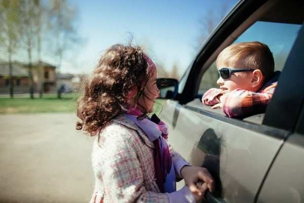 Pieni tyttö ja poika ajavat autoa — kuvapankkivalokuva