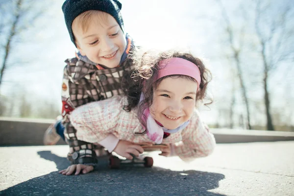 路上で小さな男の子と女の子の skaiting — ストック写真