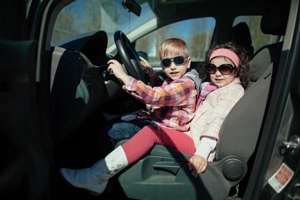 Menina e menino carro de condução — Fotografia de Stock