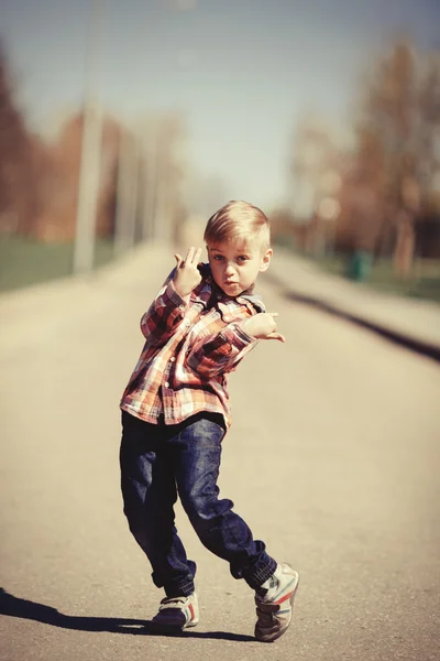 Маленький мальчик гримакает на улице — стоковое фото