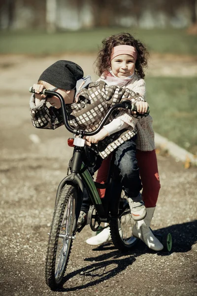 Niña y niño montando en bicicleta juntos — Foto de Stock