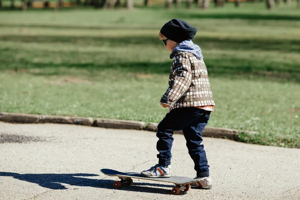 Маленький мальчик со скейтбордом на улице — стоковое фото