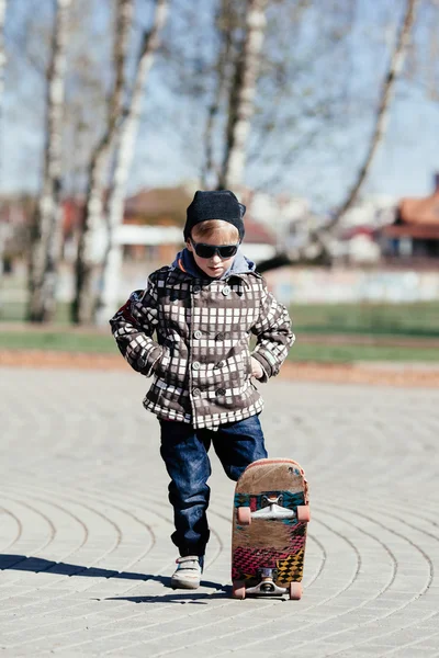 Niño pequeño con monopatín en la calle — Foto de Stock