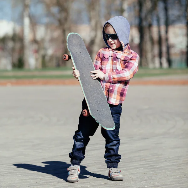 Menino com skate na rua — Fotografia de Stock