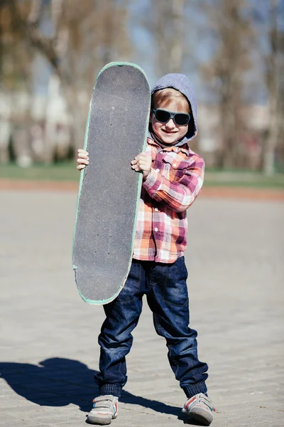 Liten pojke med skateboard på gatan — Stockfoto