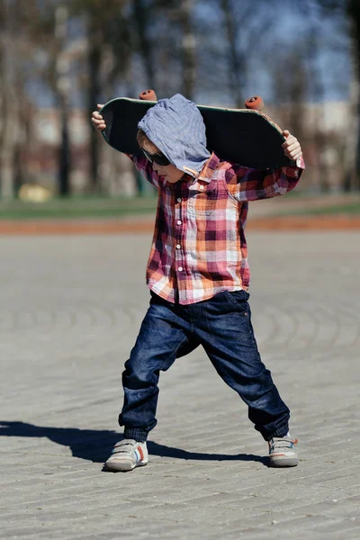 Niño pequeño con monopatín en la calle — Foto de Stock