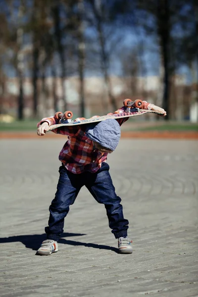 Kleine jongen met skateboard op straat — Stockfoto