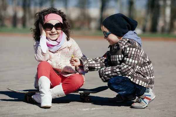 Мальчик и девочка катаются на коньках по улице — стоковое фото