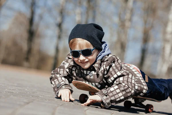 Niño pequeño con monopatín en la calle —  Fotos de Stock