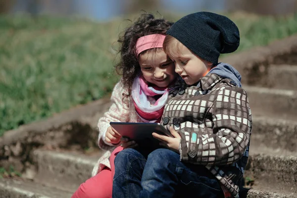 Мальчик и девочка с помощью планшета — стоковое фото