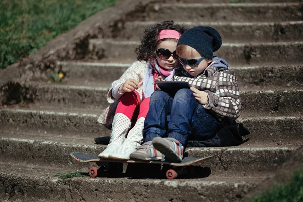 Niño y niña usando tableta — Foto de Stock