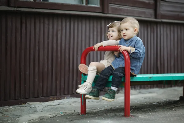 Garçon et fille assis sur banc — Photo
