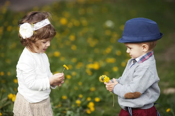 Cutle menino e menina com dente de leão — Fotografia de Stock