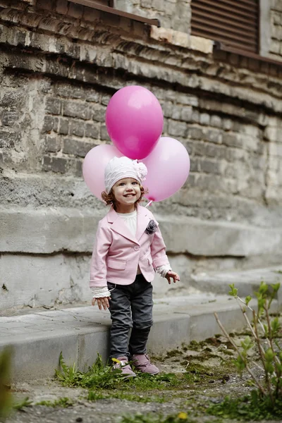 ピンクの風船都市の肖像画を持つ少女 — ストック写真