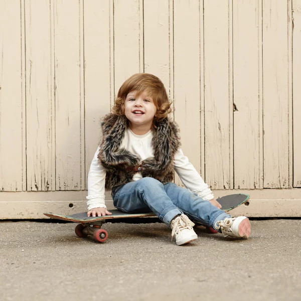 Маленька хіпстерська дівчинка з портретом скейтборду — стокове фото