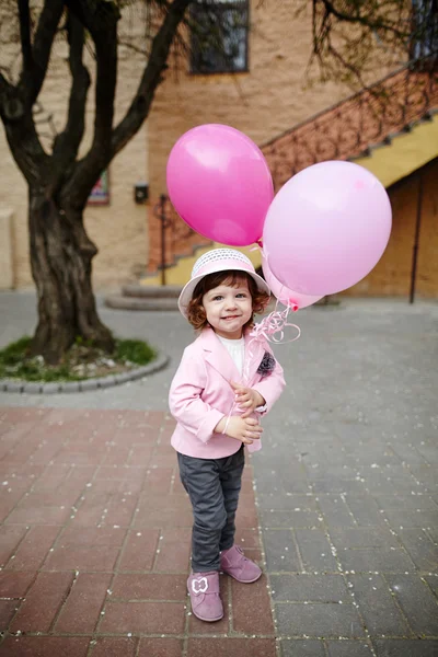 ピンクの風船都市の肖像画を持つ少女 — ストック写真